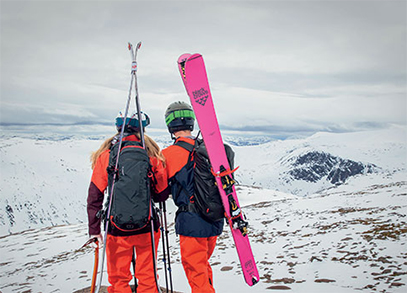 A man and woman backcountry skiing